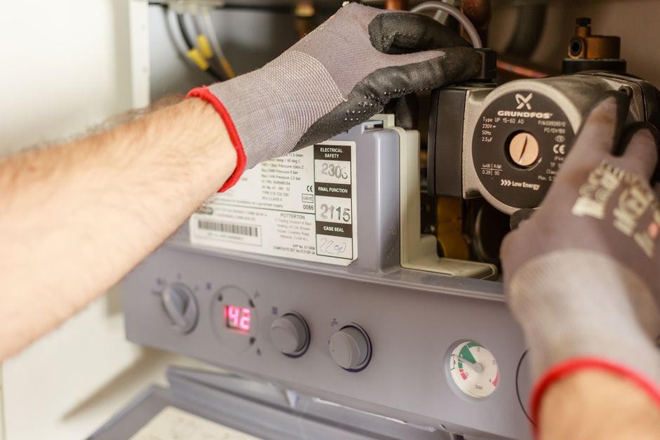 Técnico especializado realizando manutenção e conserto de aquecedor à gás
